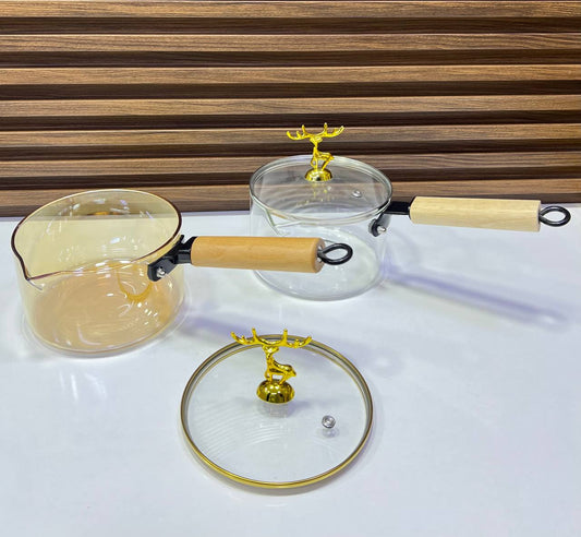Casserole en verre borosilicate transparent avec poignée en bois.