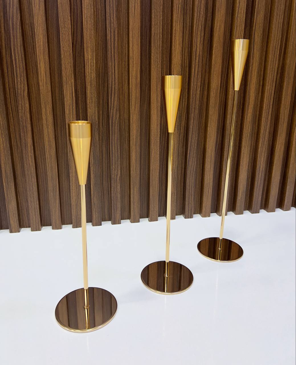 Bougeoirs dorés élégants en trois tailles, au design moderne et raffiné.
