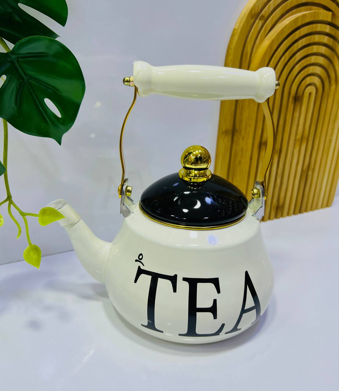 Théière élégante en céramique blanche, avec une anse dorée