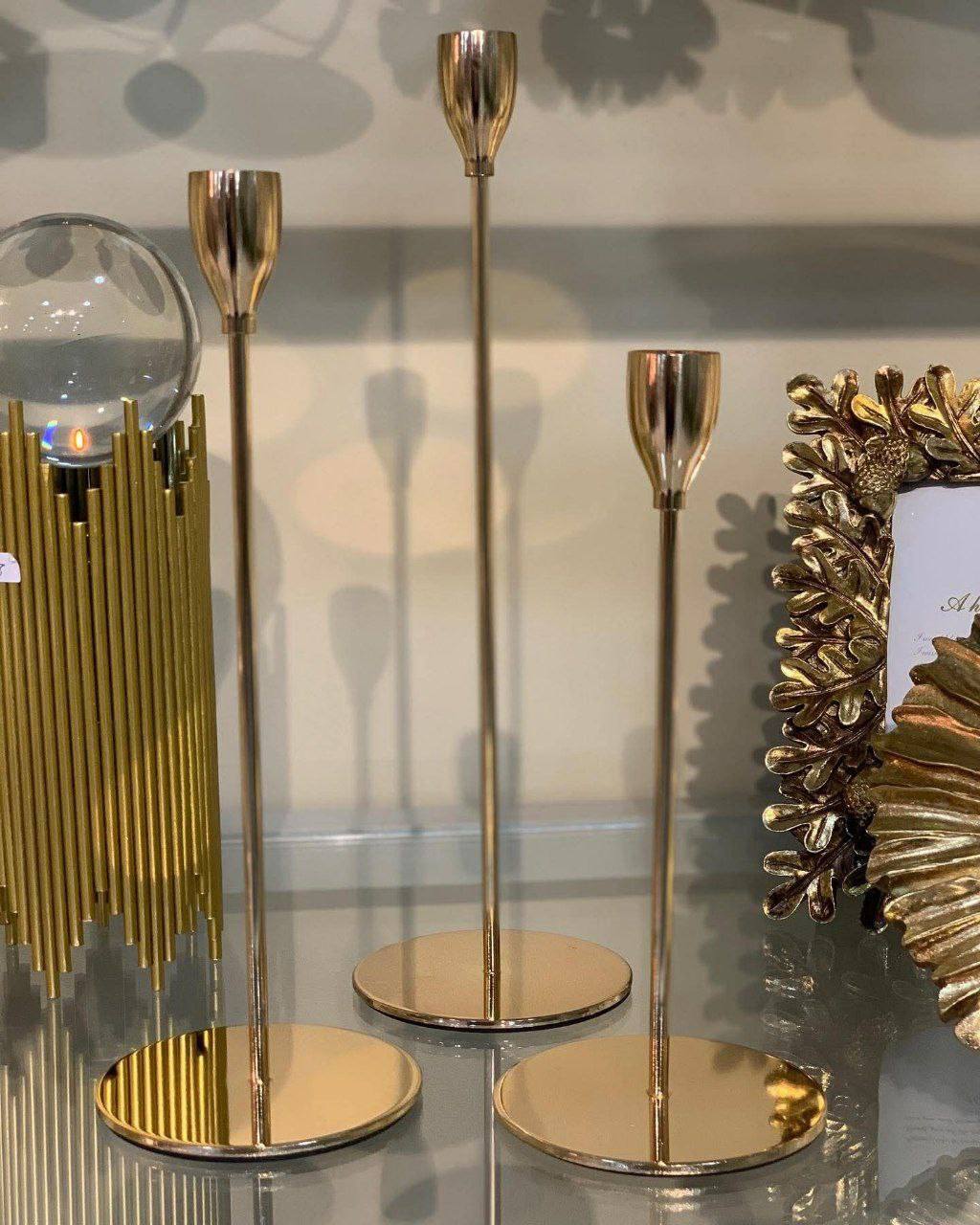 Bougeoirs dorés élégants en trois tailles, au design moderne et raffiné.
