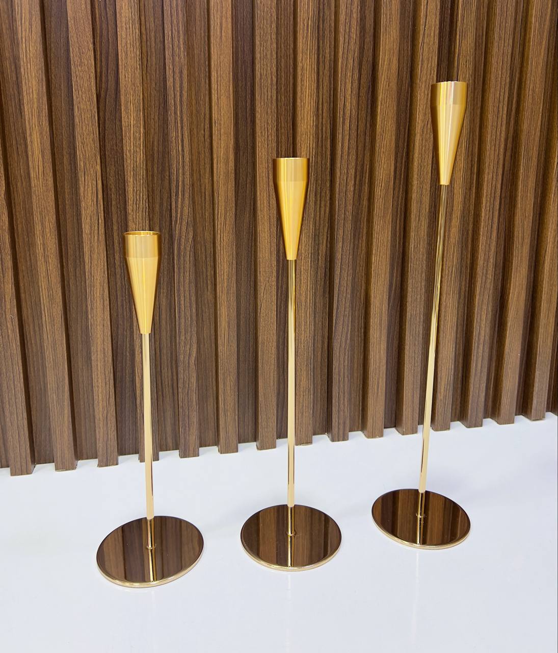 Bougeoirs dorés élégants en trois tailles, au design moderne et raffiné.