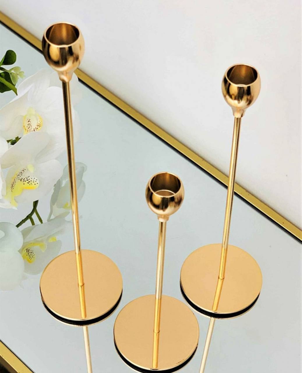 Bougeoirs dorés élégants en trois tailles, au design moderne et raffiné.